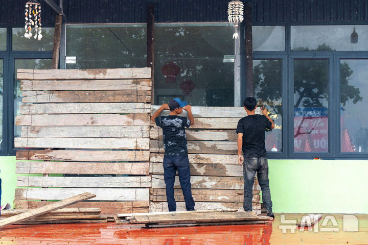 [베트남=AP/뉴시스] 21일(현지 시간) 베트남 하이퐁에서 시민들이 제6호 태풍 위파 상륙 대비를 하고 있다. 2025.07.22.