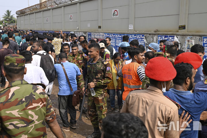[다카=AP/뉴시스] 21일 방글라데시 수도 다카에서 보안 요원들이 공군 훈련기가 추락한 학교 캠퍼스 현장에서 군중을 통제하고 있다. 2025.07.21.