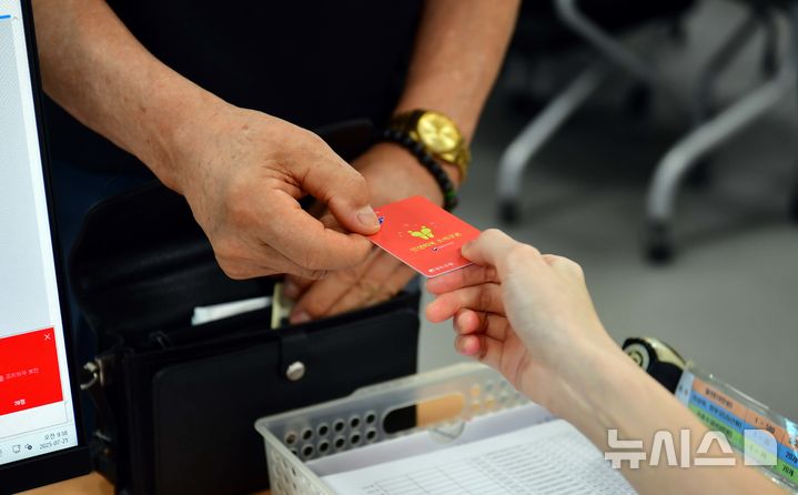 [광주=뉴시스] 이현행 기자 = 21일 오전 광주 서구 상무1동행정복지센터에서 한 주민이 민생회복 소비쿠폰 카드를 발급받고 있다. 2025.07.21. lhh@newsis.com