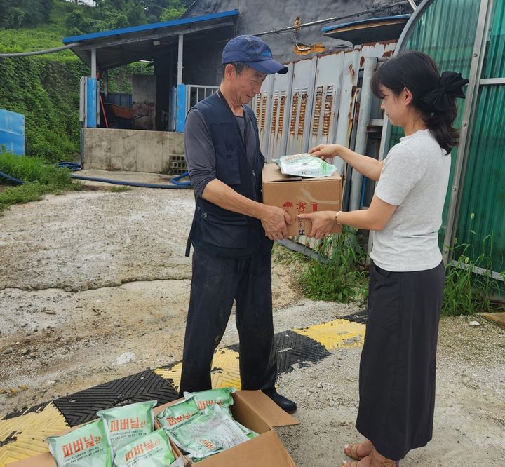 [괴산=뉴시스] 21일 충북 괴산군 한 축산 농가에서 군 직원이 농장주에게 스트레스 고온 완화제를 전달하고 있다. (사진=괴산군 제공) 2025.7.2.1 photo@newsis.com *재판매 및 DB 금지