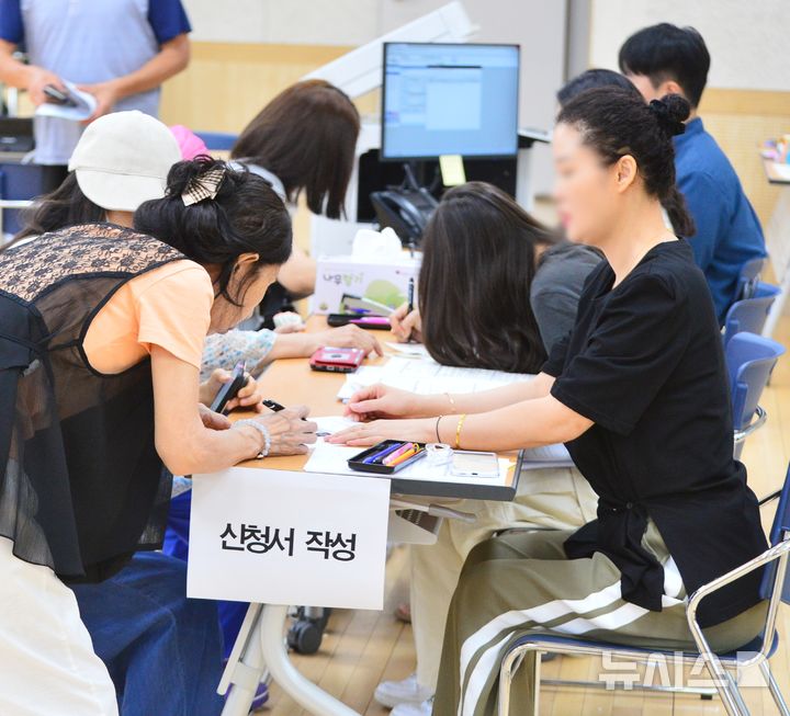 [청주=뉴시스] 서주영 기자 = 민생회복 소비쿠폰 1차 신청 첫날인 21일 충북 청주시의 율량사천동행정복지센터 3층 대회의실에서 주민들이 지원금을 신청하고 있다. 2025.07.21. juyeong@newsis.com 