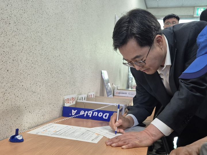 [수원=뉴시스] 이병희 기자 = 김동연 경기도지사가 '민생회복 소비쿠폰' 신청 첫날인 21일 오후 2시 수원시 영통구 원천동행정복지센터에서 민원인의 신청서 작성을 돕고 있다. 2025.07.21. iambh@newsis.com *재판매 및 DB 금지