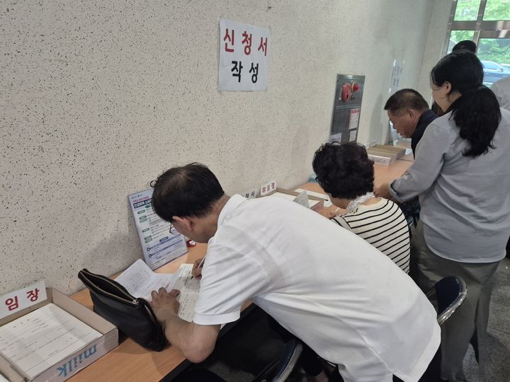 [수원=뉴시스] 이병희 기자 = '민생회복 소비쿠폰' 신청 첫날인 21일 오후 1시30분 경기 수원시 영통구 원천동주민센터에서 시민들이 '민생회복소비쿠폰' 카드 신청서를 작성하고 있다. 2025.07.21. iambh@newsis.com *재판매 및 DB 금지