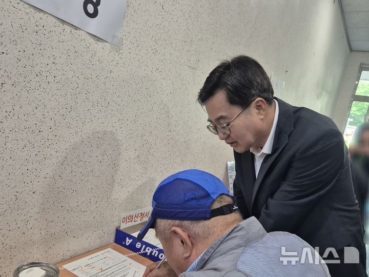 [수원=뉴시스] 이병희 기자 = 김동연 경기도지사가 '민생회복 소비쿠폰' 신청 첫날인 21일 오후 2시 수원시 영통구 원천동행정복지센터에서 민원인의 신청서 작성을 돕고 있다. 2025.07.21. iambh@newsis.com 