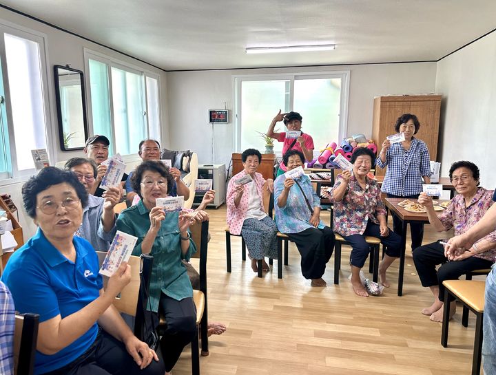 [보성=뉴시스] 21일 전남 보성군 보성읍 평촌경로당에서 주민들이 지급받은 민생회복 소비쿠폰을 들어보이고 있다. (사진 제공 = 보성군). 2025.07.21. photo@newsis.com *재판매 및 DB 금지