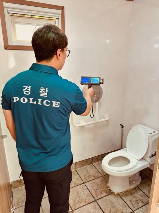 [광주=뉴시스] 광주 남부경찰서 관계자가 21일 공원 공중화장에서 몰래카메라 설치 검사를 진행하고 있다. (사진 = 광주 남부경찰서 제공) 2025.07.21. photo@newsis.com *재판매 및 DB 금지