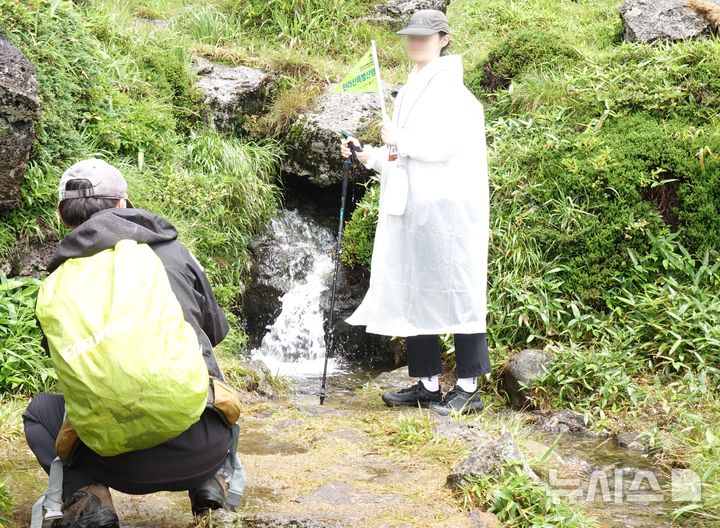 [제주=뉴시스] 양영전 기자 = 21일 오후 2025 제주 국가유산 방문의 해 시즌 '제주의 자연' 프로그램 중 하나인 한라산 비공개 구간 백록샘 탐방 참가자가 백록샘 앞에서 기념 촬영을 하고 있다.2025.07.21. 0jeoni@newsis.com