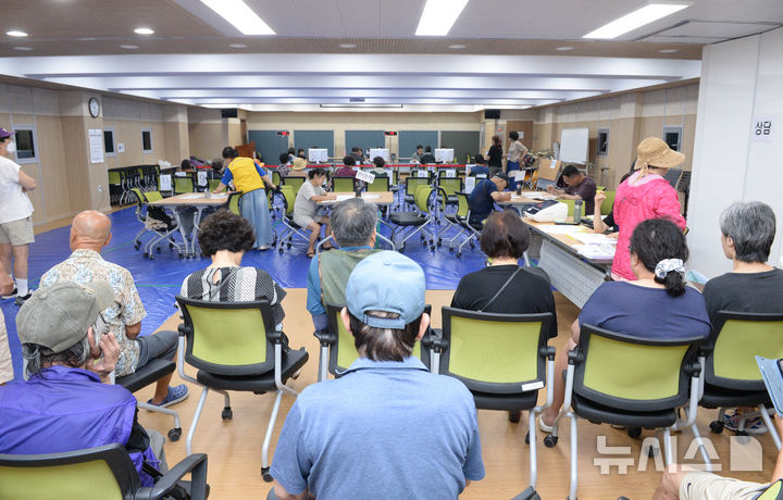 [울산=뉴시스] 배병수 기자 = 민생회복 소비쿠폰 1차 지급을 실시하는 21일 오전 울산 남구 신정1동 행정복지센터 2층 대강당에 마련된 접수 창구에서 시민들이 민생회복 소비쿠폰 카드를 발급받기위해 대기하고 있다. 2025.07.21.bbs@newsis.com.