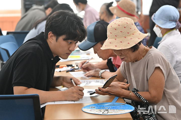 [광주=뉴시스] 이영주 기자 = 민생회복 소비쿠폰 1차 신청이 시작된 21일 오전 광주 북구 두암3동 행정복지센터에서 주민들이 선불카드 신청 상담을 하고 있다. 2025.07.21. leeyj2578@newsis.com