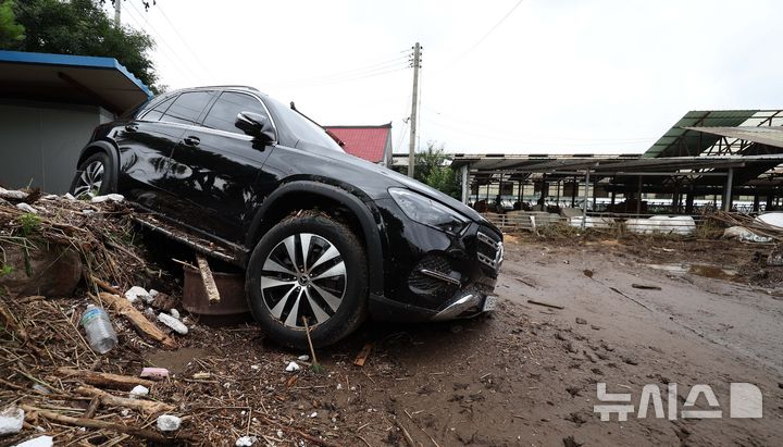 [가평=뉴시스] 김선웅 기자 = 21일 경기 가평군 대보교 인근 주택 마당에서 차량이 폭우 피해를 입고 기울어 있다. 2025.07.21. mangusta@newsis.com