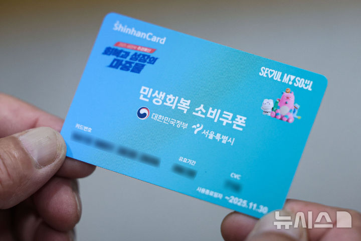 [서울=뉴시스] 권창회 기자 = 민생회복 소비쿠폰 신청 첫날인 21일 오전 서울 종로구 주민센터에서 시민이 민생회복 소비쿠폰을 받은 뒤 들어보이고 있다. 2025.07.21. kch0523@newsis.com