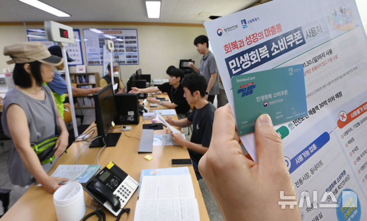 [수원=뉴시스] 김종택 기자 = 정부의 민생회복 소비쿠폰 1차 신청 첫날인 21일 경기 수원시 행궁동 행정복지센터에서 한 시민이 선불카드를 수령하고 있다.&nbsp; 소비쿠폰 신청은 요일제에 따라 출생 연도 끝자리 1·6은 월요일, 2·7은 화요일, 3·8은 수요일, 4·9는 목요일, 5·0은 금요일에 신청할 수 있다.&nbsp; 주말에는 온라인 신청만 가능하며 사용기한은 11월 30일까지다. 2025.07.21. jtk@newsis.com