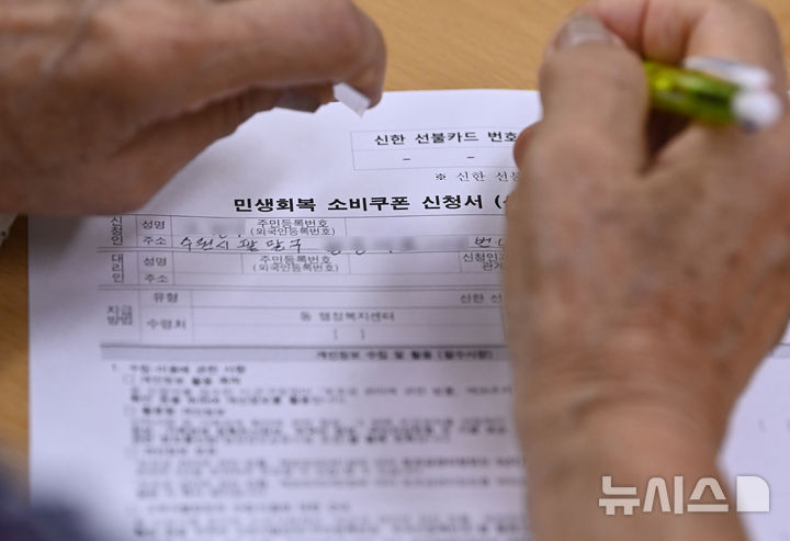 [수원=뉴시스] 김종택 기자 = 정부의 민생회복 소비쿠폰 1차 신청 첫날인 21일 경기 수원시 행궁동 행정복지센터에서 한 시민이 지원금 신청서를 작성하고 있다.   소비쿠폰 신청은 요일제에 따라 출생 연도 끝자리 1·6은 월요일, 2·7은 화요일, 3·8은 수요일, 4·9는 목요일, 5·0은 금요일에 신청할 수 있다.   주말에는 온라인 신청만 가능하며 사용기한은 11월 30일까지다. 2025.07.21. jtk@newsis.com