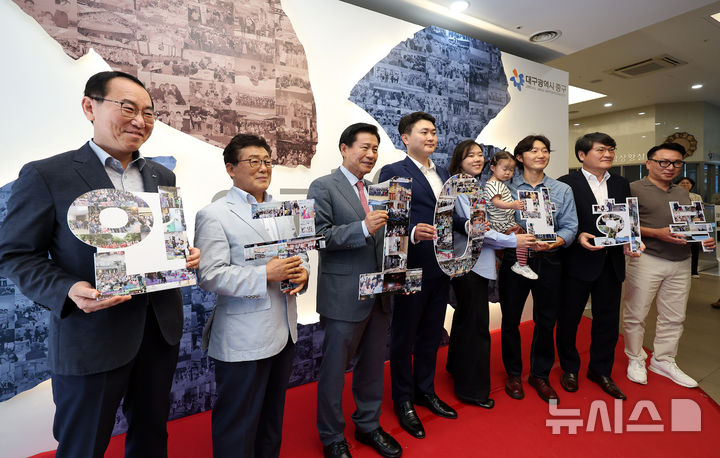 [대구=뉴시스] 이무열 기자 = 21일 대구 중구청 로비에서 열린 대구 중구 인구 10만 회복 기념식에서 류규하 중구청장을 비롯한 참석자들이 포토존에서 ‘인구 10만 회복 글자 퍼즐’을 들고 기념촬영을 하고 있다. 2025.07.21. lmy@newsis.com