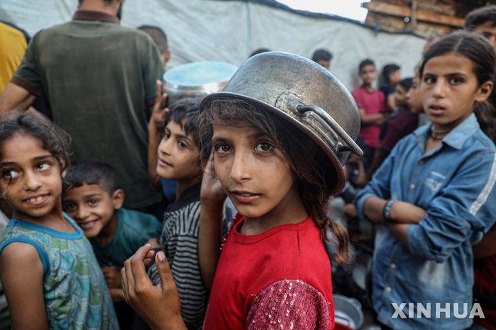 [가자시티=신화/뉴시스] 지난 20일(현지 시간) 가자지구 가자시티 중심가에 있는 식량 배급소에서 구호 음식을 받으려는 팔레스타인 어린이들이 식기를 들고 기다리고 있다. 가자 보건 당국은 지난 3월 이스라엘의 가자지구 봉쇄 이후 굶어 죽은 사람이 86명에 달하며, 이 중 76명이 어린이라고 밝혔다. 2025.07.22.