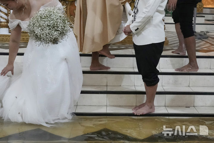 [말로로스=AP/뉴시스] 22일(현지 시간) 필리핀 불라칸 주 말로로스 바라소인 교회에서 열린 결혼식. 2025.07.23.