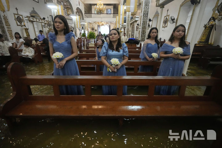 [말로로스=AP/뉴시스] 22일(현지 시간) 필리핀 불라칸 주 말로로스 바라소인 교회에서 열린 결혼식에 참석한 신부 들러리. 2025.07.23.