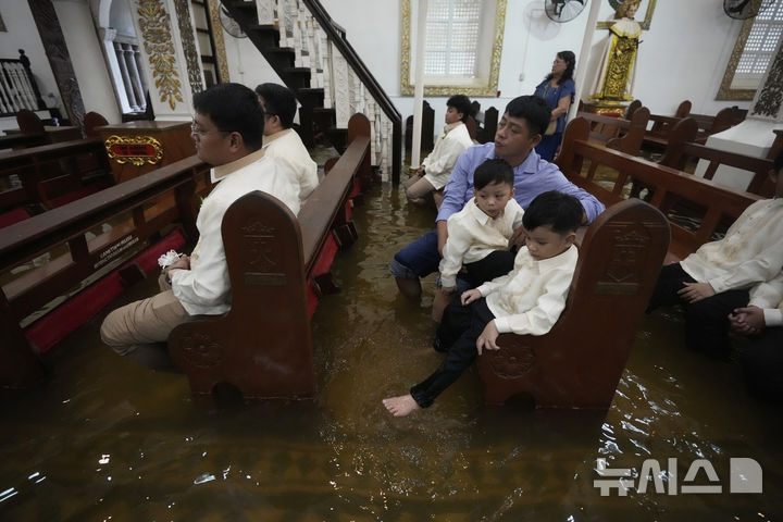 [말로로스=AP/뉴시스] 22일(현지 시간) 필리핀 불라칸 주 말로로스 바라소인 교회에서 열린 결혼식에 하객들이 참석하고 있다. 2025.07.23.
