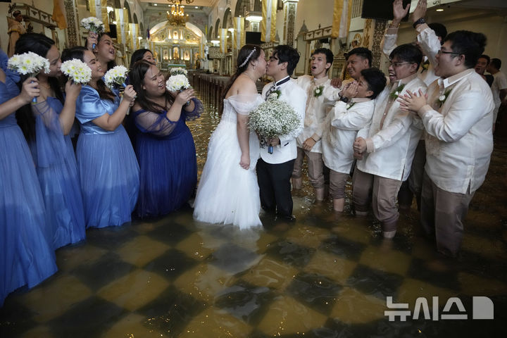[말로로스=AP/뉴시스] 22일(현지 시간) 필리핀 불라칸 주 말로로스 바라소인 교회에서 열린 결혼식에서 신혼부부가 입맞춤을 하고 있다. 2025.07.23.