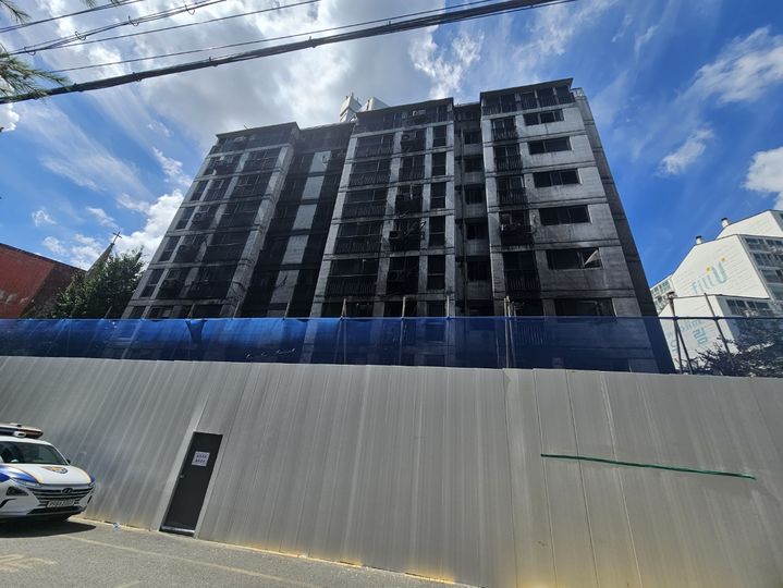 [광명=뉴시스] 문영호 기자 = 경기 광명시 소하동 화재 아파트 전경. 안전상의 문제로 아파트 주위에 펜스를 두른 후 출입문을 달아놓았다. 입주민이 거주하던 세대에서 생활물품을 가지고 나오기 위해 경찰과 동행해 아파트 내부로 들어갔다.2025.07.22.sonanom@newsis.com *재판매 및 DB 금지