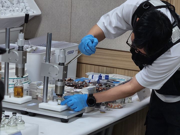 [서울=뉴시스] 이승주 기자=식품의약품안전처 특별사법경찰이 압류한 물품으로 무허가 의약품 제조 과정을 시연하고 있다. 2025.07.22. heyjude@newsis.com *재판매 및 DB 금지