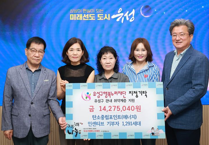 [대전=뉴시스] 조명휘 기자 = 정용래(오른쪽) 대전 유성구청장이 22일 탄소중립포인트제 기부 참여자의 인센티브 1427만 5000원을 유성구 행복누리재단에 지정 기탁하고 있다. (사진= 유성구 제공) 2025.07.22. photo@newsis.com *재판매 및 DB 금지