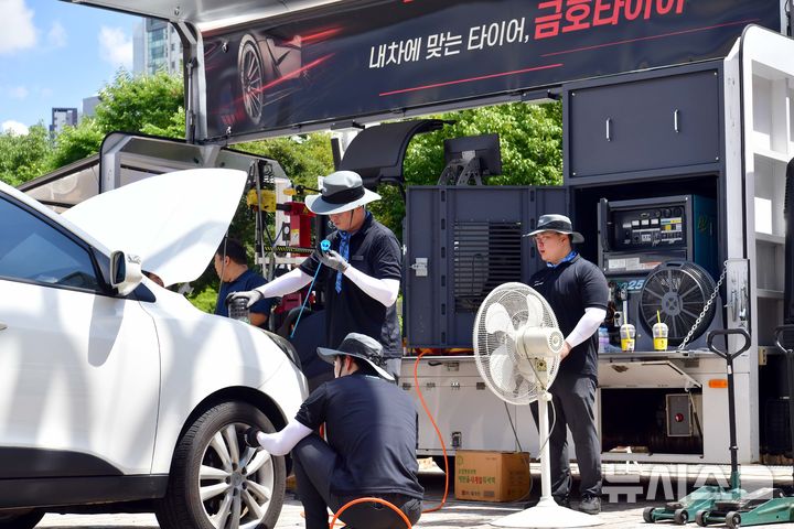 [광주=뉴시스] 이현행 기자 = 금호타이어 관계자들이 22일 오후 광주 서구 시청 야외음악당에 마련한 '자동차 타이어 무상점검 정비소'에서 시민들의 차량을 무상점검 하고 있다. 2025.07.22. lhh@newsis.com