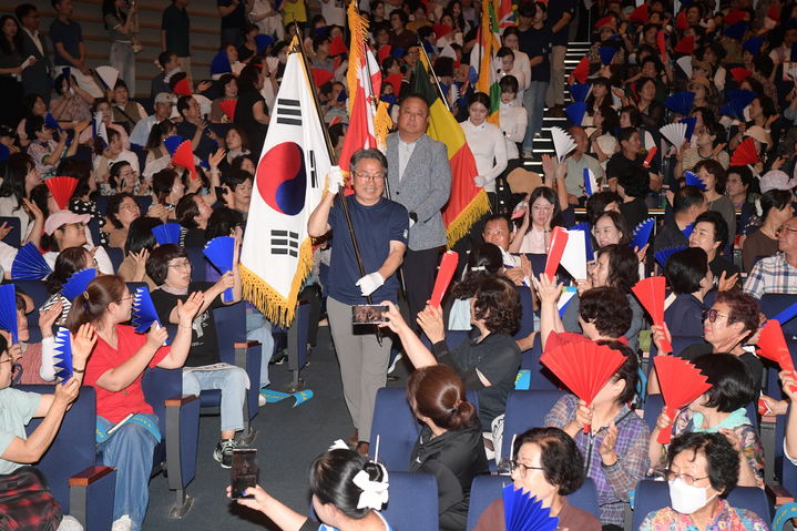 [광주=뉴시스] 송창헌 기자 =강기정 광주시장이 22일 오후 시청 대회의실에서 열린 광주 2025 세계양궁선수권대회 시민 서포터즈 발대식에 참석, 광주시 양궁선수단과 함께 태극기와 대회 홍보기, 참여국가 국기 등을 들고 입장하고 있다. (사진=광주시 제공) 2025.07.22 photo@newsis.com *재판매 및 DB 금지