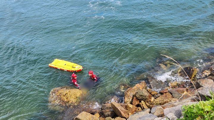 [태안=뉴시스] 22일 오후 3시께 충남 태안 신진항 인근 해안가에서 해경이 숨져 있는 70대를 옮기고 있다. (사진=태안해양경찰서 제공) 2025.07.22. photo@newsis.com *재판매 및 DB 금지