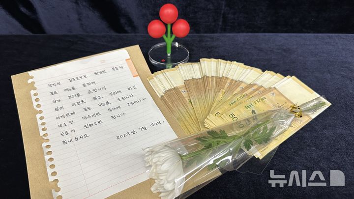 [창원=뉴시스]경남 익명의 기부천사가 22일 경남사회복지공동모금회 사무실로 퀵 배달시킨 상자에 들어 있은 집중호우 피해 지원 성금 500만 원과 손편지, 그리고 국화 꽃 한송이.(사진=경남공동모금회 제공) 2025.07.22. photo@newsis.com