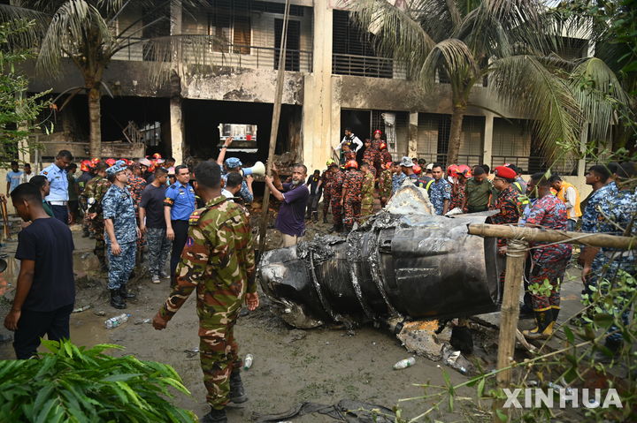 [다카=신화/뉴시스] 21일(현지 시간) 방글라데시 다카에서 방글라데시 공군 훈련기가 한 학교에 추락한 뒤 경찰과 소방관들이 현장을 수습하고 있다. 2025.07.22.