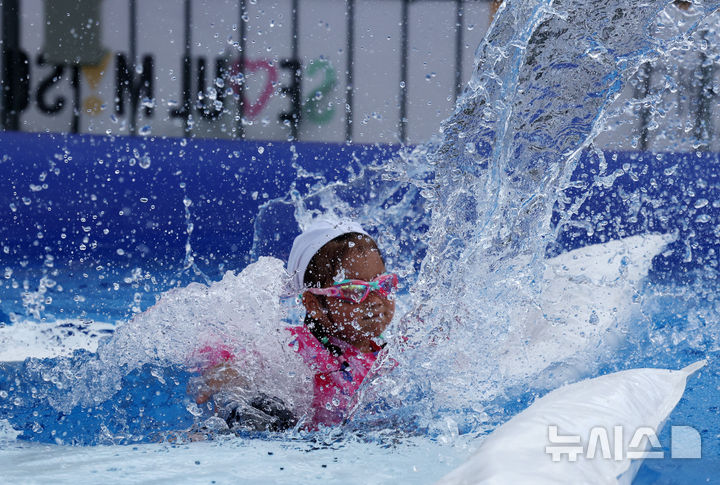 [서울=뉴시스] 배훈식 기자 = 절기상 가장 덥다는 대서(大暑)인 22일 오후 서울 종로구 광화문광장에서 열린 2025 서울썸머비치를 찾은 한 아이가 물 미끄럼틀을 타며 더위를 이겨내고 있다. 2025.07.22. dahora83@newsis.com