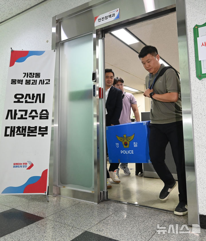 [오산=뉴시스] 김종택 기자 = 경기남부경찰청 수사전담팀이 22일 경기 오산시청에서 옹벽 붕괴 사망사고와 관련한 압수수색을 마친 뒤 압수품을 옮기고 있다. 2025.07.22. jtk@newsis.com