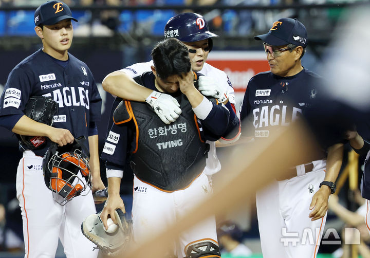 [서울=뉴시스] 홍효식 기자 = 22일 서울 송파구 잠실야구장에서 열린 2025 KBO리그 한화 이글스와 두산 베어스의 경기, 6회말 2사 한화 포수 최재훈이 두산 양의지의 헛스윙 삼진 때 마스크를 맞고 고통을 호소하고 있다. 2025.07.22. yesphoto@newsis.com