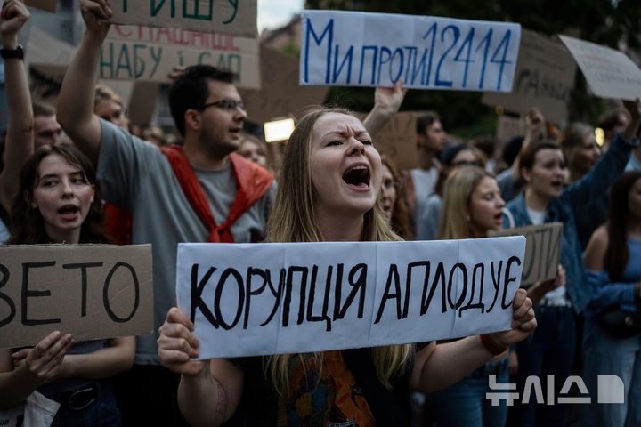 [키이우=AP/뉴시스] 22일(현지 시간) 우크라이나 키이우에서 반부패 기관의 독립성을 박탈하는 정부의 법안 통과에 항의하는 시위에 참여한 여성이 손팻말을 들고, 구호를 외치고 있다. 2025.07.23.