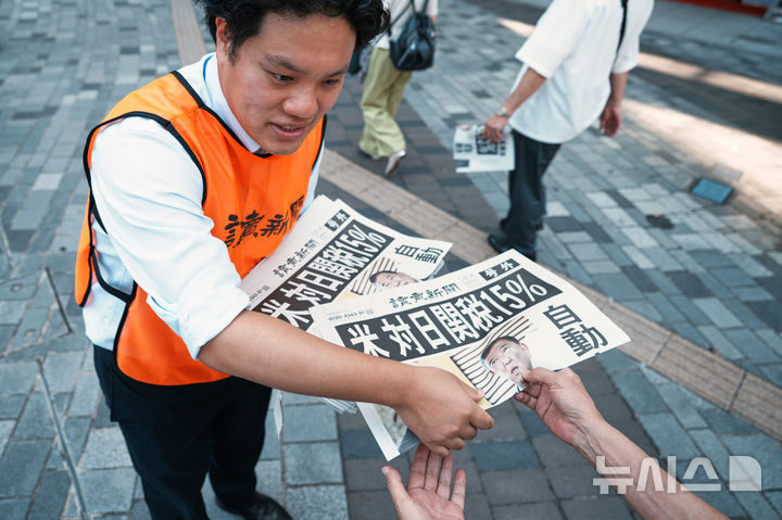 [도쿄=AP/뉴시스] 23일 일본 도쿄에서 요미우리 신문사의 한 직원이 도널드 트럼프 미국 대통령이 일본과 무역 협상을 완료했다는 내용을 보도한 신문 호외판을 배포하고 있다. 신문 1면에는 '미국, 일본에 15% 관세'라는 제목의 기사가 실렸다. 2025.07.23.