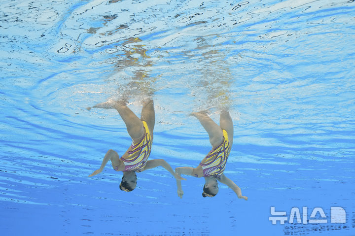 [싱가포르=AP/뉴시스] 프랑스의 라엘리스 알라베즈와 로망 루넬이 23일(현지 시간) 싱가포르에서 열린 2025 국제수영연맹(World Aquatics) 싱가포르 세계수영선수권대회 아티스틱 스위밍 여자 듀엣 프리 예선전에서 연기하고 있다. 2025.07.23.