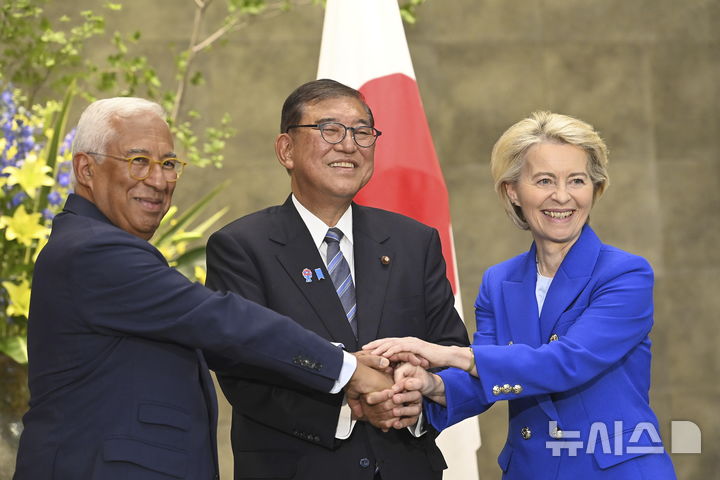 [=AP/뉴시스]지난 23일 일본 도쿄 총리 관저에서 유럽연합(EU)과 일본의 정상회담 전 정상들이 손을 잡고 기념 촬영하고 있다. 왼쪽부터 안토니우 코스타 EU 정상회의 상임의장, 이시바 시게루 일본 총리, 우르줄라 폰데어라이엔 EU 집행위원장 . 2025.07.24.