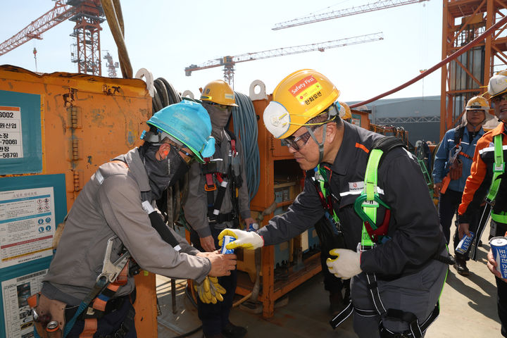 [거제=뉴시스] 신정철 기자= 한화오션 김희철 대표이사는 여름철 폭염으로 인한 현장 근로자들의 온열질환 예방을 위해 23일 거제사업장 생산 현장에서 근로자들의 휴식 공간 환경 등을 점검하고 온열질환 예방 지원 활동을 펼쳤다.사진은 한화오션 김희철 대표이사(오른쪽)가 건조 중인 LNG운반선 위에서 근로자들에게 시원한 음료를 건네고 있다.(사진=한화오션 제공).2025.07.23. photo@newsis.com *재판매 및 DB 금지