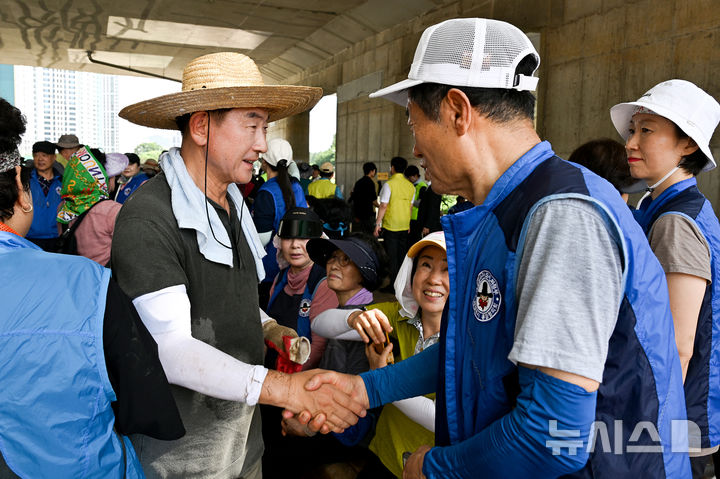 [의정부=뉴시스] 김동근 경기 의정부시장이 23일 하천변 집중호우 피해 복구 작업 현장에서 참여자들과 소통하고 있다. (사진=의정부시 제공) 2025.07.23. photo@newsis.com 