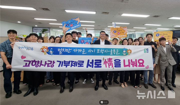 [포항=뉴시스] 23일 포항시청에서 총무새마을과·정보통신과·읍면동 직원 등 40여명이 울릉군에 고향사랑기부금을 전달하고 기념 촬영하는 모습. (사진=포항시 제공) 2025.07.23. photo@newsis.com