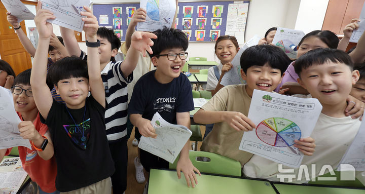 [서울=뉴시스] 김선웅 기자 = 23일 서울 동작구 서울삼일초등학교에서 4학년3반 학생들이 여름방학식을 갖고 방학 계획표를 들어 보이고 있다. 2025.07.23. mangusta@newsis.com