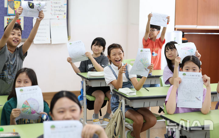 [서울=뉴시스] 김선웅 기자 = 23일 서울 동작구 서울삼일초등학교에서 4학년3반 학생들이 여름방학식을 갖고 방학 계획표를 들어 보이고 있다. 2025.07.23. mangusta@newsis.com