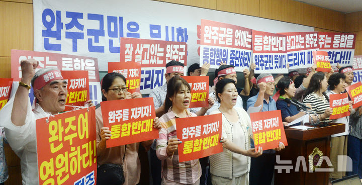 [전주=뉴시스] 김얼 기자 = 완주-전주통합반대 완주군민대책위원회 관계자들이 23일 전북 전주시 전북특별자치도의회 기자회견장에서 완주-전주 통합행위 즉각 중단 기자회견을 열고 구호를 외치고 있다. 2025.07.23. pmkeul@newsis.com