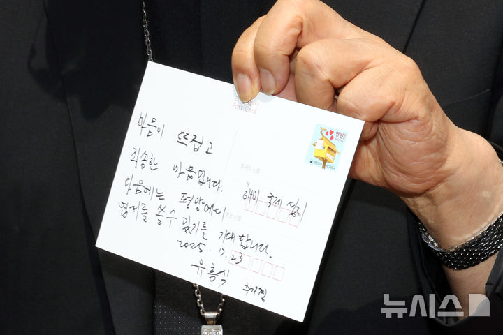[파주=뉴시스] 국회사진기자단=유흥식 추기경이 23일 경기도 파주 임진각 평화누리공원 통일기원 느린우체통에 '마음이 뜨겁고 죄송한 마음입니다. 다음에는 평양에서 엽서를 쓸수 있기를 기대합니다'라고 쓴 엽서를 들어보이고 있다.2025.07.23. photo@newsis.com