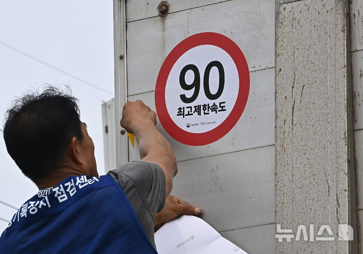 [화성=뉴시스] 김종택 기자 = 23일 경기 화성시 한 화물차 운행기록장치(DTG)점검센터에서 관계자가 화물차 후면에 최고 제한속도 스티커를 부착하고 있다. 국토교통부와 한국교통안전공단(TS)은 오늘부터 총중량 3.5t(톤)을 초과하는 화물차를 대상으로 ‘최고 제한속도(90㎞/h) 스티커’를 부착하는 시범사업을 실시했다. 2025.07.23. jtk@newsis.com