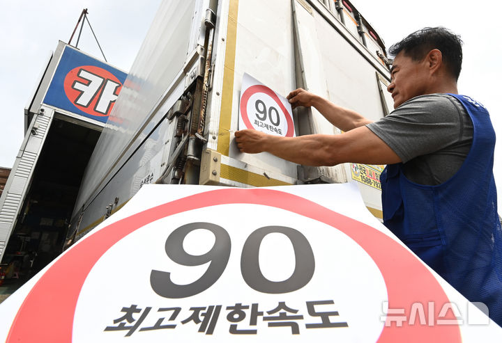 [화성=뉴시스] 김종택 기자 = 23일 경기 화성시 한 화물차 운행기록장치(DTG)점검센터에서 관계자가 화물차 후면에 최고 제한속도 스티커를 부착하고 있다. 국토교통부와 한국교통안전공단(TS)은 오늘부터 총중량 3.5t(톤)을 초과하는 화물차를 대상으로 ‘최고 제한속도(90㎞/h) 스티커’를 부착하는 시범사업을 실시했다. 2025.07.23. jtk@newsis.com