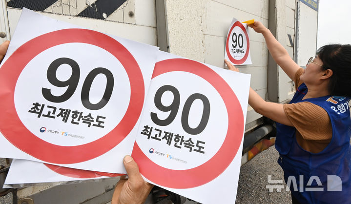 [화성=뉴시스] 김종택 기자 = 23일 경기 화성시 한 화물차 운행기록장치(DTG)점검센터에서 관계자들이 화물차 후면에 최고 제한속도 스티커를 부착하고 있다. 국토교통부와 한국교통안전공단(TS)은 오늘부터 총중량 3.5t(톤)을 초과하는 화물차를 대상으로 ‘최고 제한속도(90㎞/h) 스티커’를 부착하는 시범사업을 실시했다. 2025.07.23. jtk@newsis.com