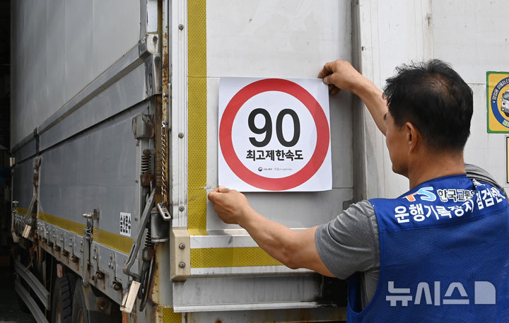 [화성=뉴시스] 김종택 기자 = 23일 경기 화성시 한 화물차 운행기록장치(DTG)점검센터에서 관계자가 화물차 후면에 최고 제한속도 스티커를 부착하고 있다. 국토교통부와 한국교통안전공단(TS)은 오늘부터 총중량 3.5t(톤)을 초과하는 화물차를 대상으로 ‘최고 제한속도(90㎞/h) 스티커’를 부착하는 시범사업을 실시했다. 2025.07.23. jtk@newsis.com