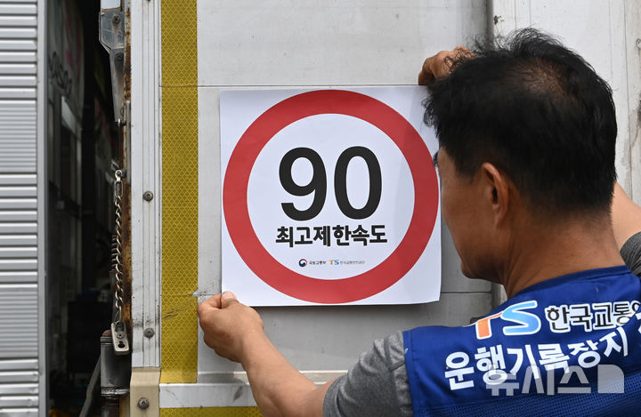 [화성=뉴시스] 김종택 기자 = 23일 경기 화성시 한 화물차 운행기록장치(DTG)점검센터에서 관계자가 화물차 후면에 최고 제한속도 스티커를 부착하고 있다. 국토교통부와 한국교통안전공단(TS)은 오늘부터 총중량 3.5t(톤)을 초과하는 화물차를 대상으로 ‘최고 제한속도(90㎞/h) 스티커’를 부착하는 시범사업을 실시했다. 2025.07.23. jtk@newsis.com
